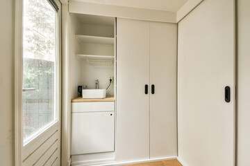 A sleek and modern laundry room featuring minimalist cabinetry and a bright, airy design. Ideal for small spaces, it combines functionality with style.