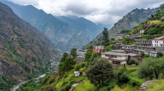 A scenic view unfolds revealing a charming village led amidst lush green hills and majestic mountains under an overcast sky in a remote valley landscape.