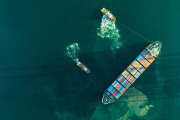 Top view of a large cargo ship loading and unloading containers at a deep-sea port. This aerial...