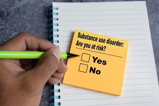 Concept of Substance use disorder - are you at risk yes or no write on sticky notes isolated on Wooden Table.