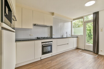A contemporary kitchen featuring sleek cabinetry, modern appliances, and ample natural light, showcasing a minimalist aesthetic for functional cooking space.