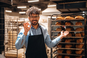 Bakery worker in apron is standing indoors