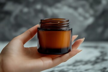 "Hand holding amber glass jar, minimalistic cosmetic container for skincare or beauty products, clean and natural packaging concept"