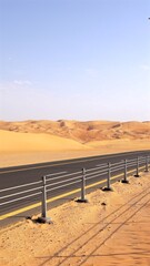 Straight road with rail lines cuts through vast golden sand, sleek barrier echoes rhythm of dune ridges, symbol of modern travel in timeless silence, iconic tourist attraction.