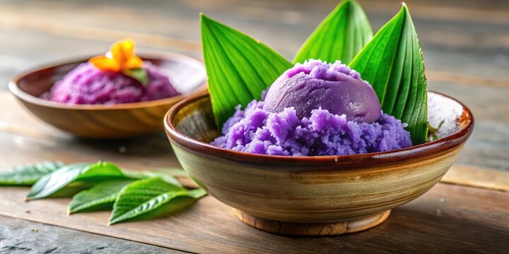 Colorful ube halaya in a traditional ceramic bowl with a few fresh ube leaves and a sprinkle of shaved ice on top