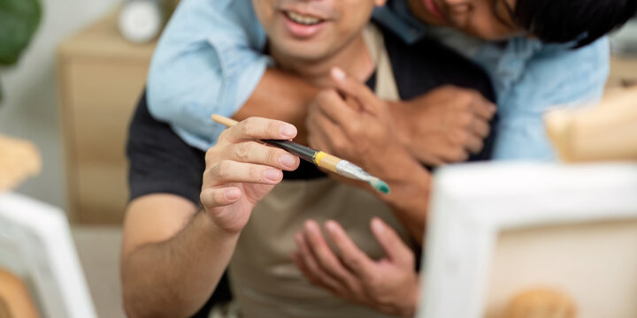 Couple and Painting Fun. A gay couple enjoying a playful moment while painting together in a cozy environment. - Powered by Adobe