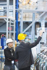 Quality inspectors team and workers at factory using machines