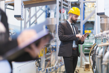 Quality inspectors team and workers at factory using machines