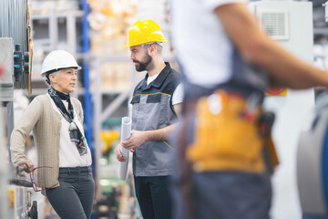 Senior female engineer talking to young coworker in the factory