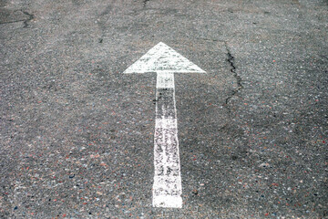 white arrow on the road indicating the direction