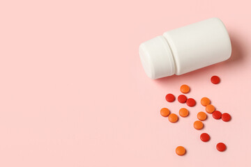Jar with different pills on pink background, closeup