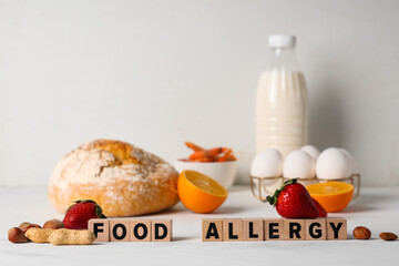 Text FOOD ALLERGY with different products on white table, closeup