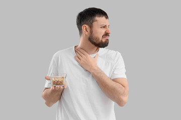 Young man with nuts on light background. Food Allergy Awareness Month