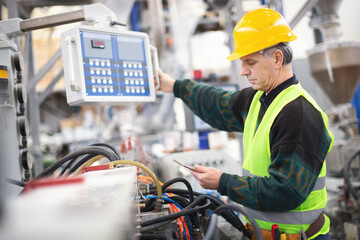 Senior worker in the factory operating machines