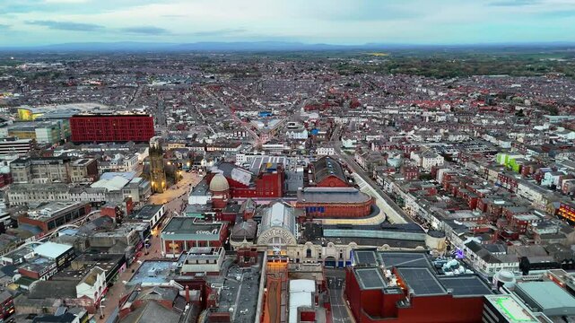 Aerial drone shot pushes forward over Blackpool town centre at dusk, showcasing Winter Gardens and the urban landscape