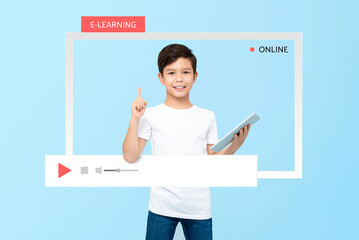 Cute mixed race Asian boy student holding tablet computer and pointing hand up in the frame,...