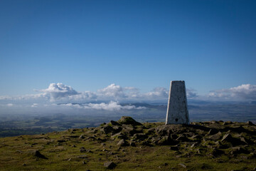 a view of the beacon at the top of Clee hill with the mist on the ground bellow