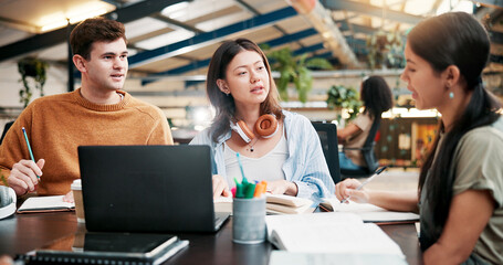Students, college and discussion for education in library, learning or brainstorming on laptop. Computer, people and group in university for research project on textbook, studying and writing notes