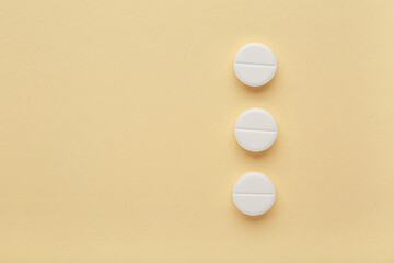 White pills on yellow background