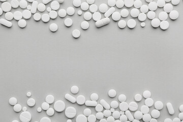 Different white pills on grey background