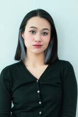 Obraz premium Female model with modern hairstyle posing against a minimalist background in a stylish outfit
