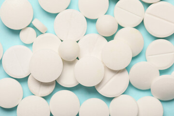 Many white pills on blue background