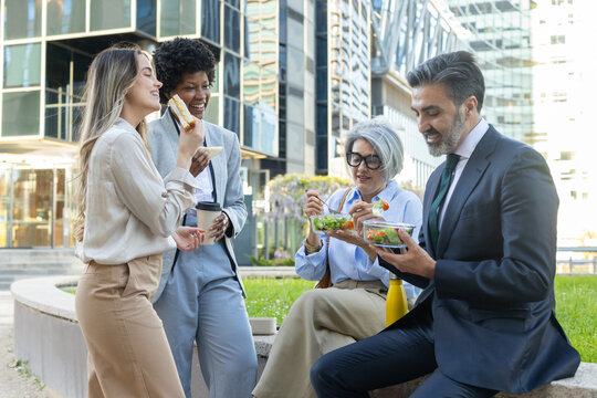 Businesspeople eating healthy lunch outdoors together