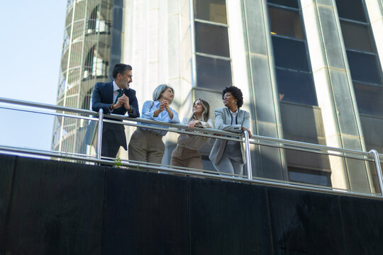 Business people talking on balcony of modern office building