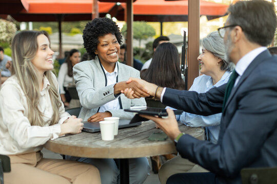 Business people shaking hands closing a deal at outdoor cafe