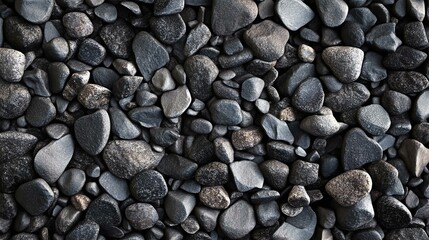 Close-up of a variety of smooth, dark stones creating a textured surface. Perfect for backgrounds or natural themes.