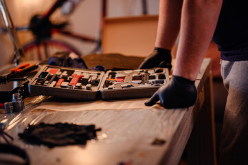 Man Leaning Over Workbench with Open Bike Tool Kit