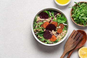 Quinoa salad with arugula, beetroot and carrot. Detox, diet, healthy salad in white bowl on light background
