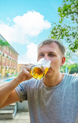 Fototapeta premium Close up of man drinking beer from glass at the open air near the pool. Alcohol and leisure concept.