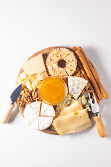 Wooden board with various cheese and olives. Brie. Camembert. Parmesan, feta, blue cheese. Italian, French cheese