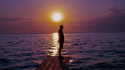 Silhouette of person standing alone on wooden pier at sunset over calm sea reflecting solitude contemplation mental health hope loneliness inner peace journey