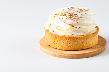 Lemon tartlets with whipped cream, sprinkles and chocolate chips on white background