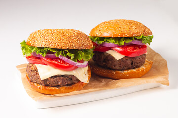 Hamburger made of beef, onion, tomato, lettuce, cheese and spices. Fresh burger closeup. Cheeseburger.