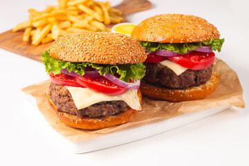 Hamburger made of beef, onion, tomato, lettuce, cheese and spices. Fresh burger closeup. Cheeseburger.
