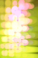 Soft glowing bokeh light effect with bright yellow and pink tones on a green background. Great for festive or dreamy visuals