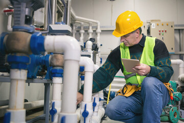 Senior maintenance engineer checking the system in the boiler room