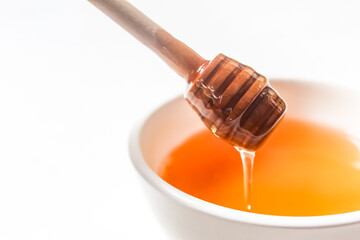 honey dripping in a bowl isolated on white background