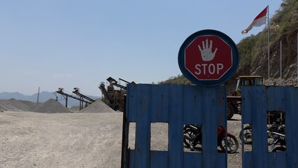 Prominent red stop sign at the restricted border of an aviary natural stone exploitation...