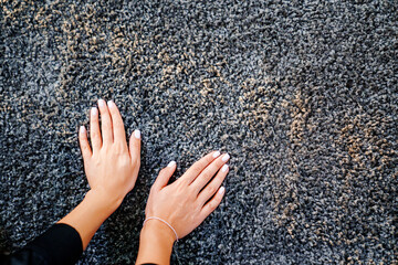 a woman's hand touching the grey Interior pile carpet 