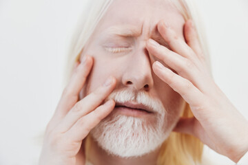 Stress, emotions, pain, health, mental wellness A man with white hair and beard, holding his face...