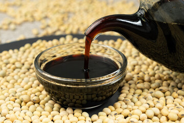 Close-up of the process of pouring soy sauce into a saucepan.