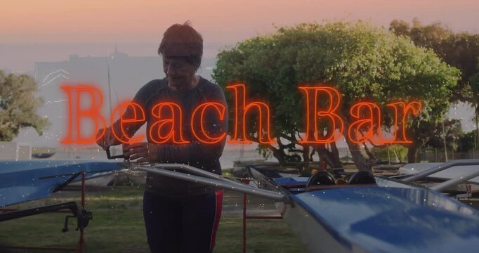 Senior female rower adjusting boat rigging in health training at sunset with neon Beach Bar overlay