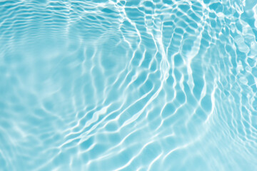 Blue water with ripples on the surface. Defocus blurred transparent blue colored clear calm water surface texture with splashes and bubbles. Water waves with shining pattern texture background.