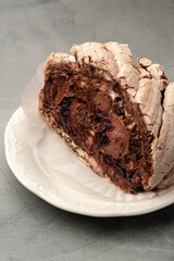 Delicious chocolate meringue roulade on a white plate in a neutral setting