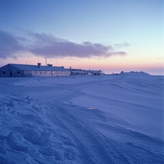 Arctic research station at dawn.  Snow-covered landscape.  Sunrise over buildings