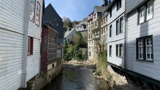 Traditional timberframe houses and wooden buildings at Monschau city historic centre. Motion of Rur (Roer) river water. Monschau, Germany
